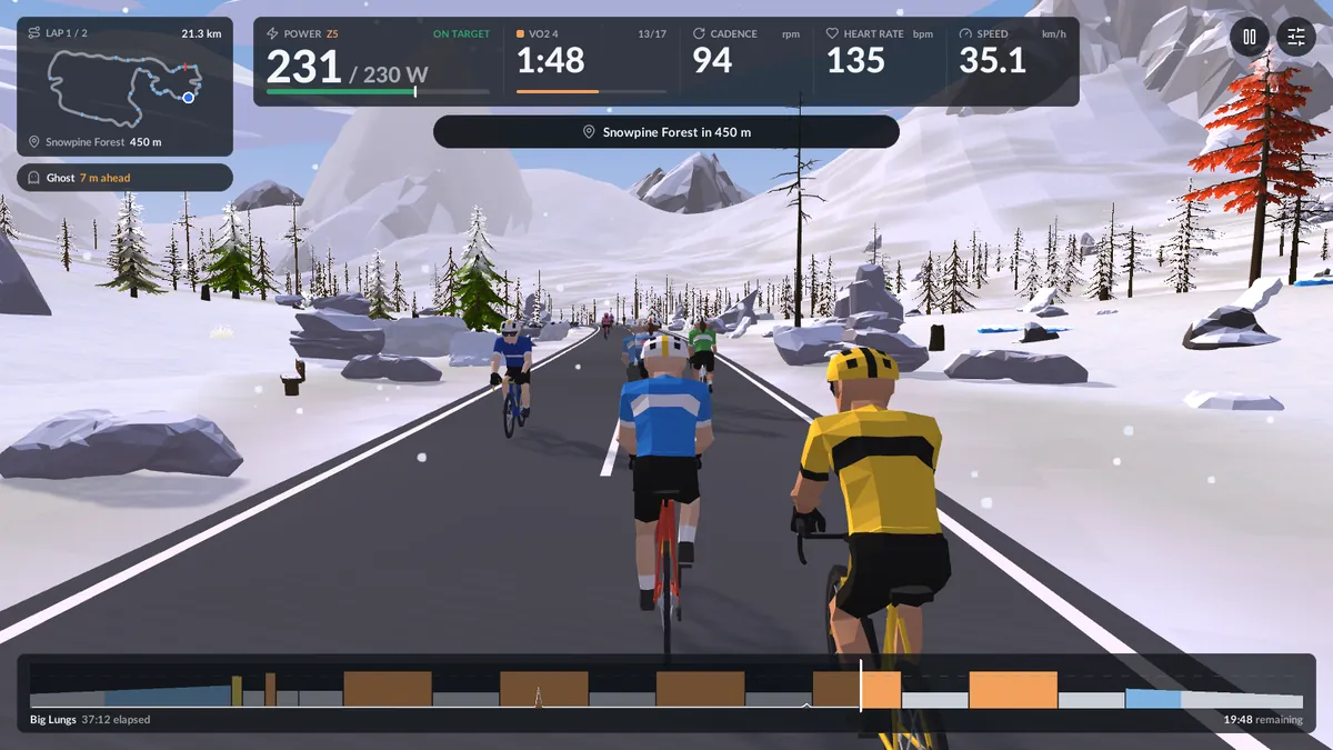 The ride screen in the snow: power against target, interval timer, cadence, heart rate and speed along the top, a lap map on the left and the workout profile along the bottom.